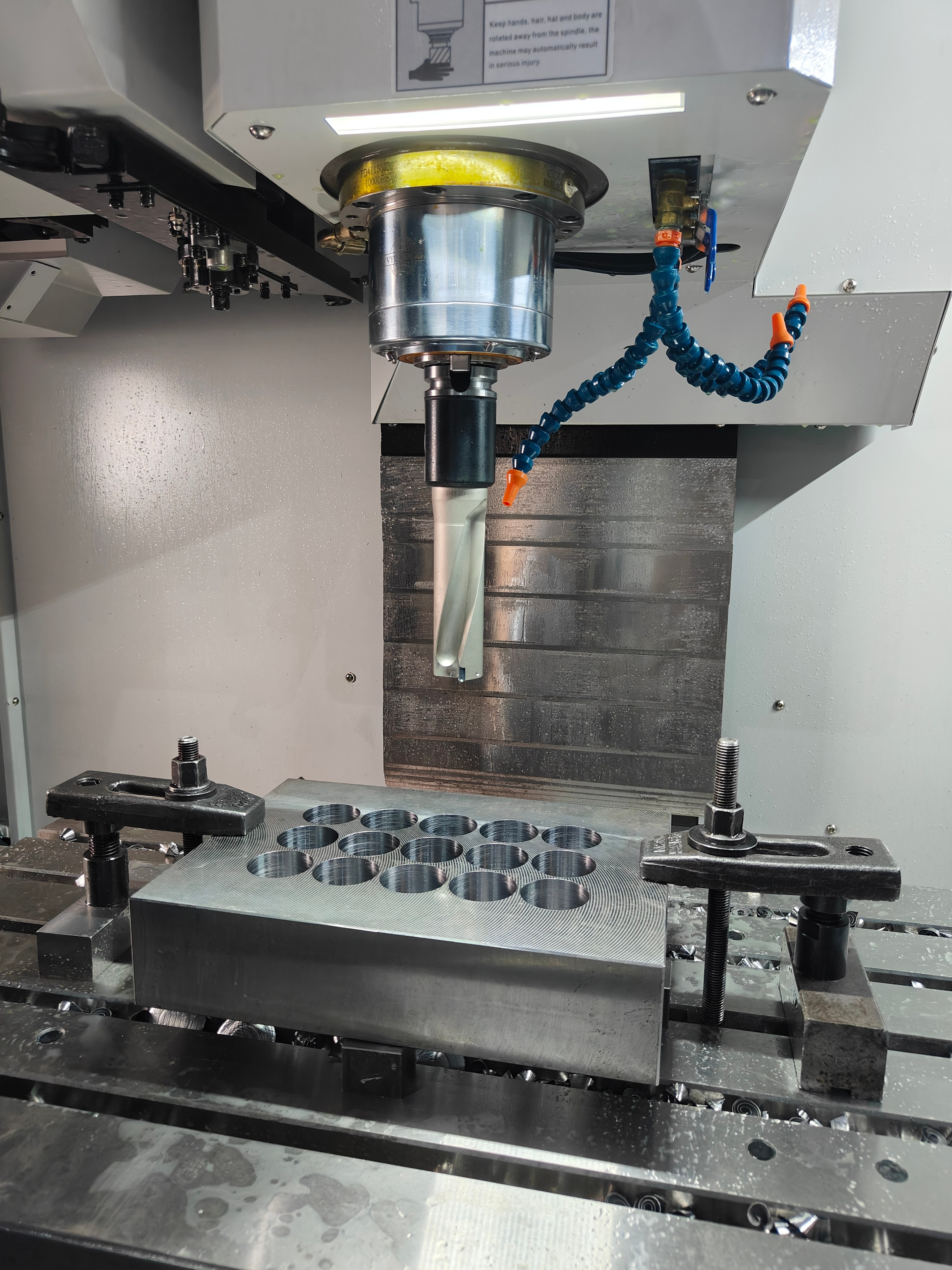 Deep-hole drilling setup on a mold base plate in a CNC machining center