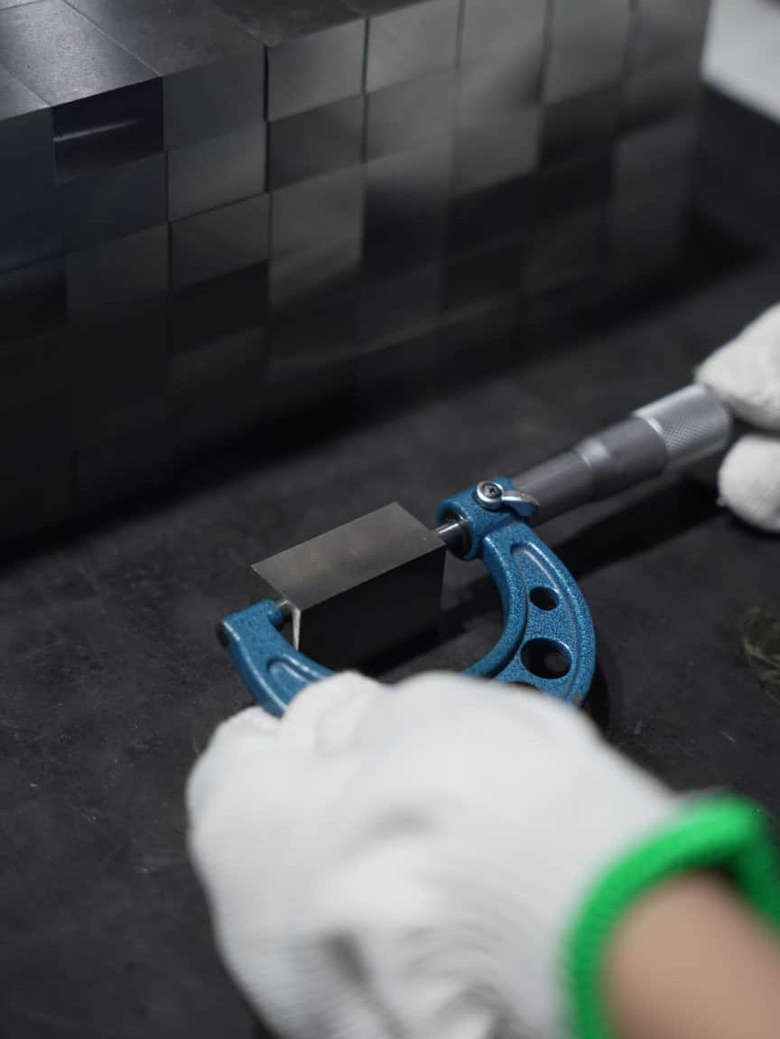Micrometer measuring the dimensions of a mold steel block