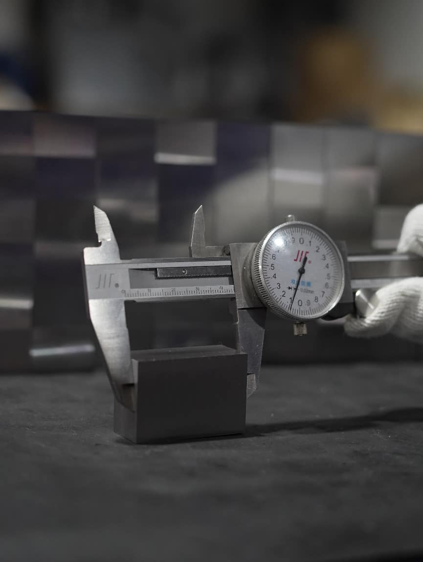 Caliper measuring a mold steel block during incoming inspection